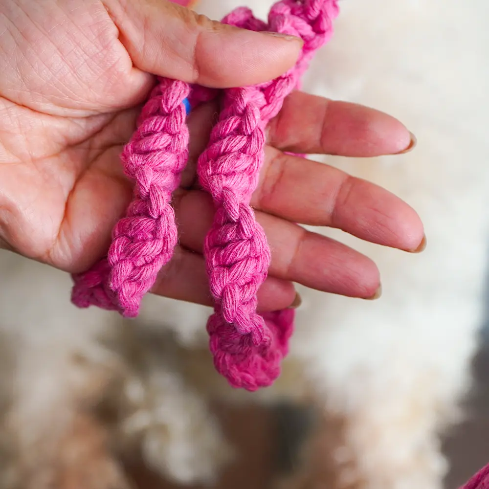 Manos con tejido de macrame en color rosado