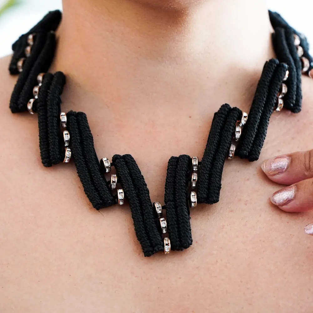 Joya hecho de macramé sobre cuello de mujer