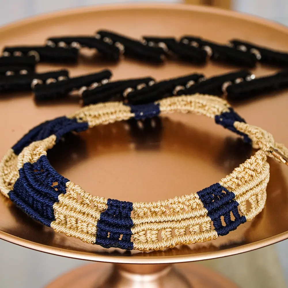 Dos joyas hechos de macramé sobre platillo dorado