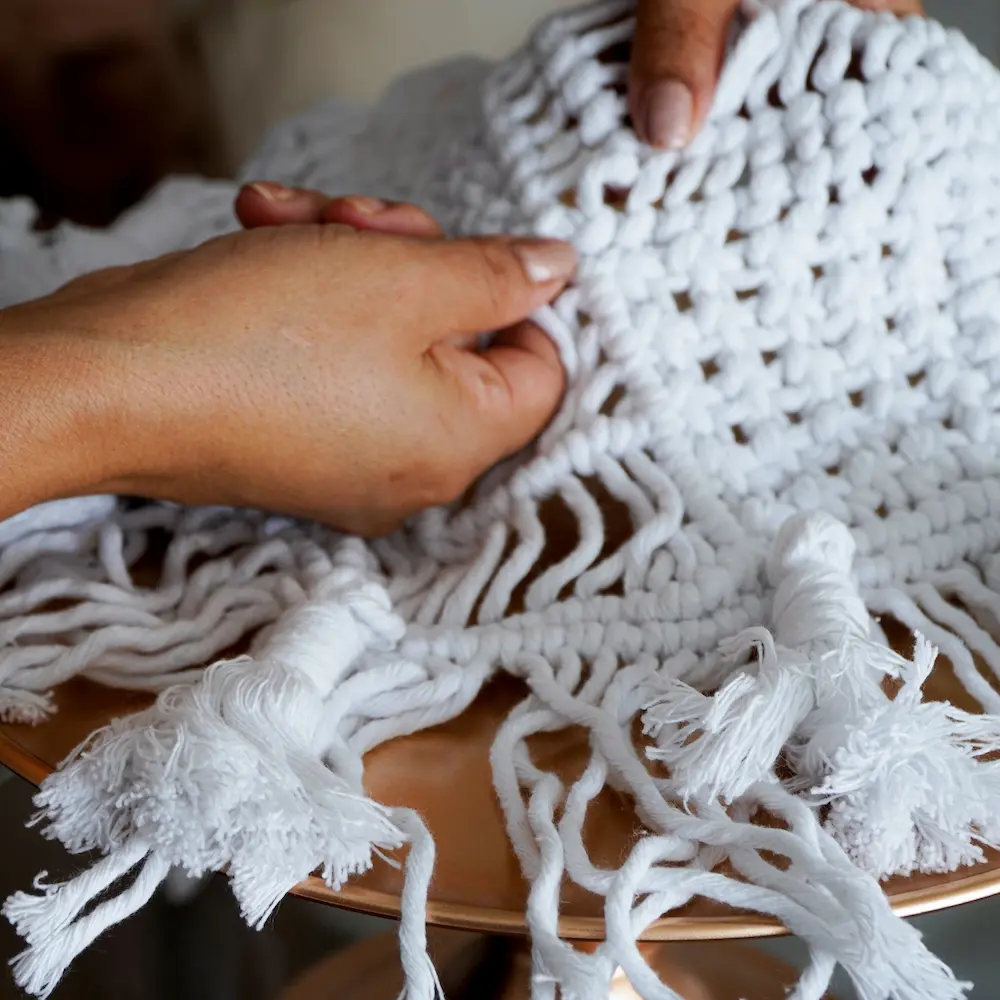 Manos de mujer mostrando nudo de macramé