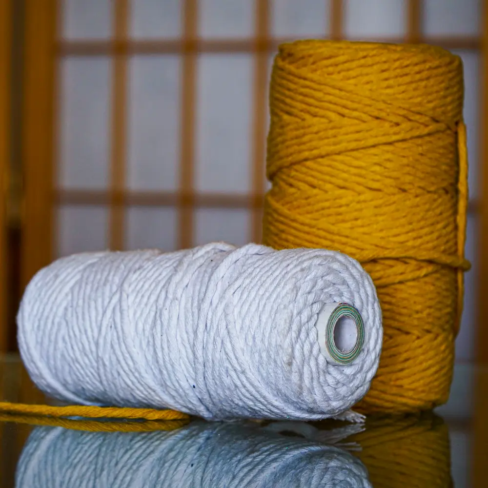 Hilos de algodón de color blanco y amarillo sobre la mesa